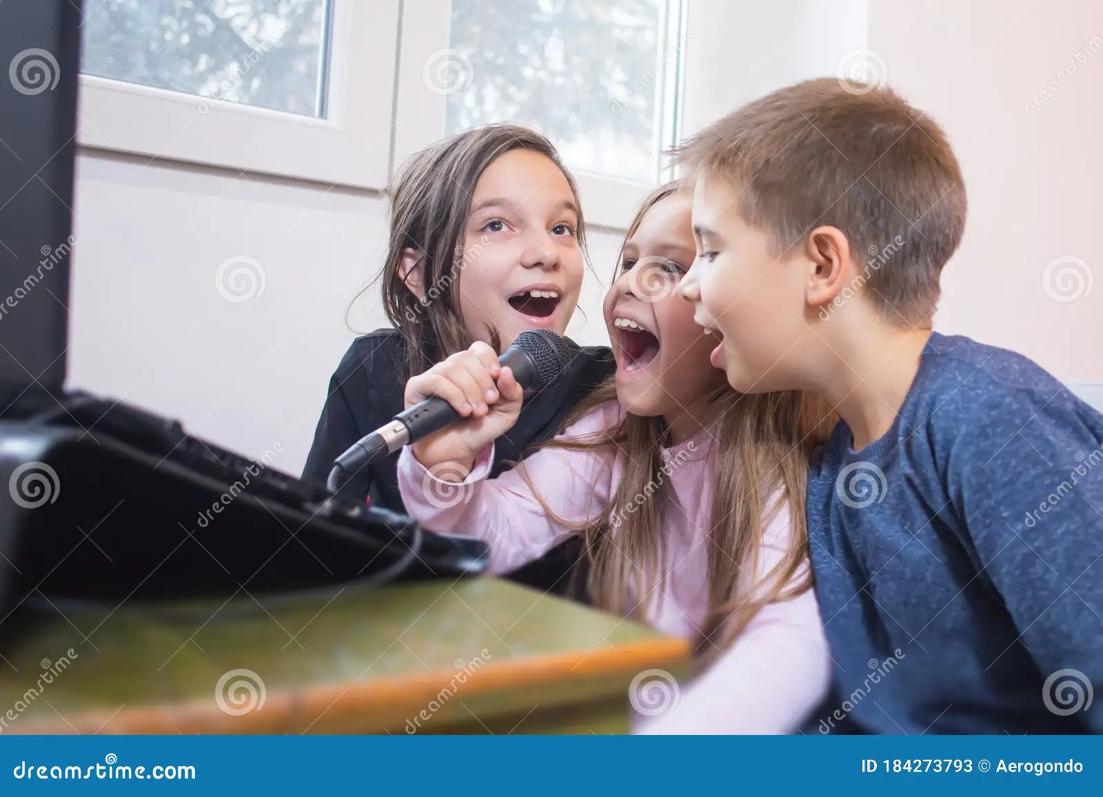 niños-cantando-karaoke-juntos-tres-184273793